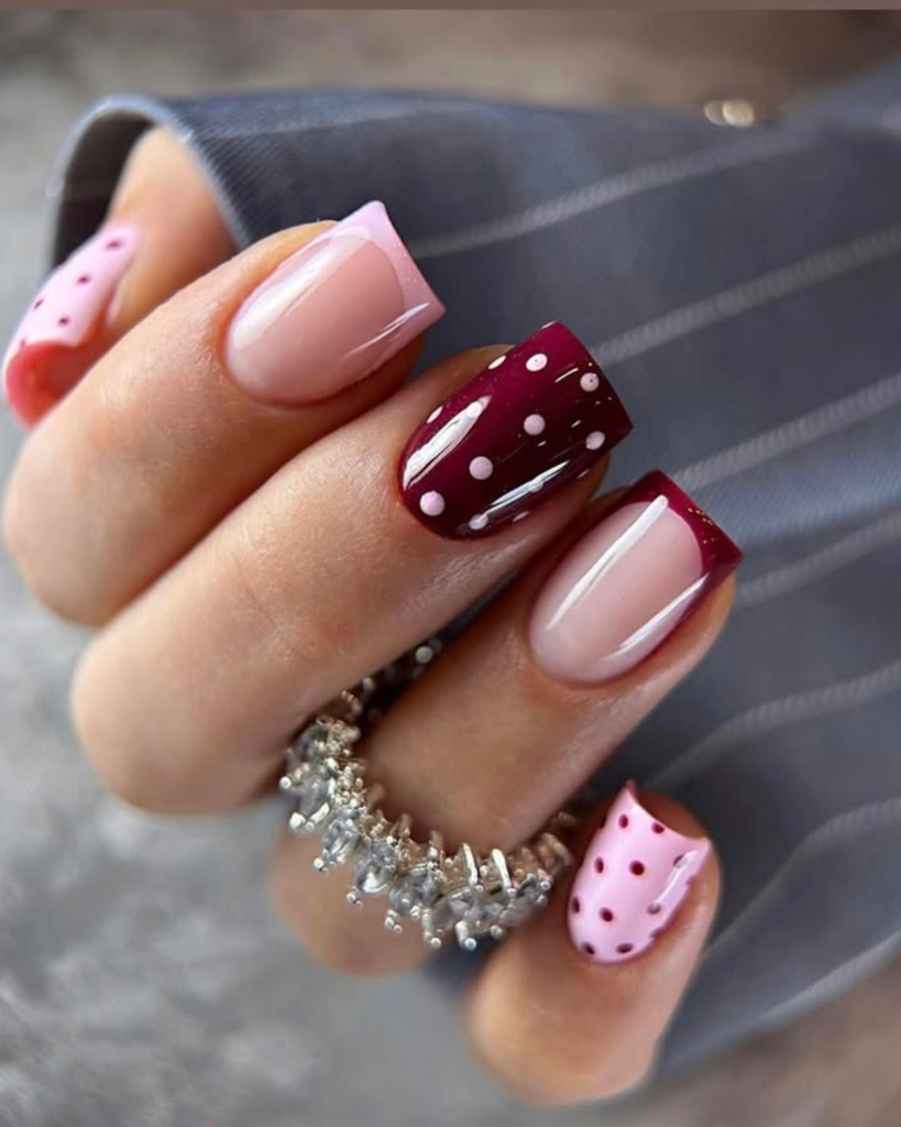 Short square nails with burgundy and pink polka dots and French tips. Short nail design